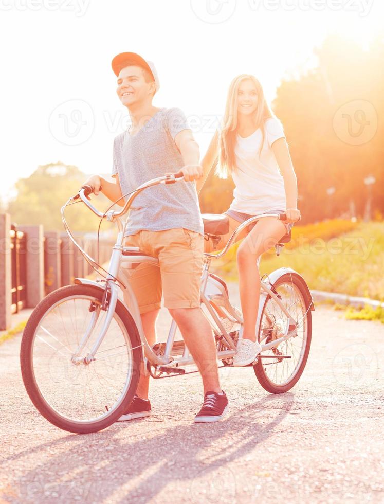 contento Pareja montando un bicicleta en el ciudad calle foto