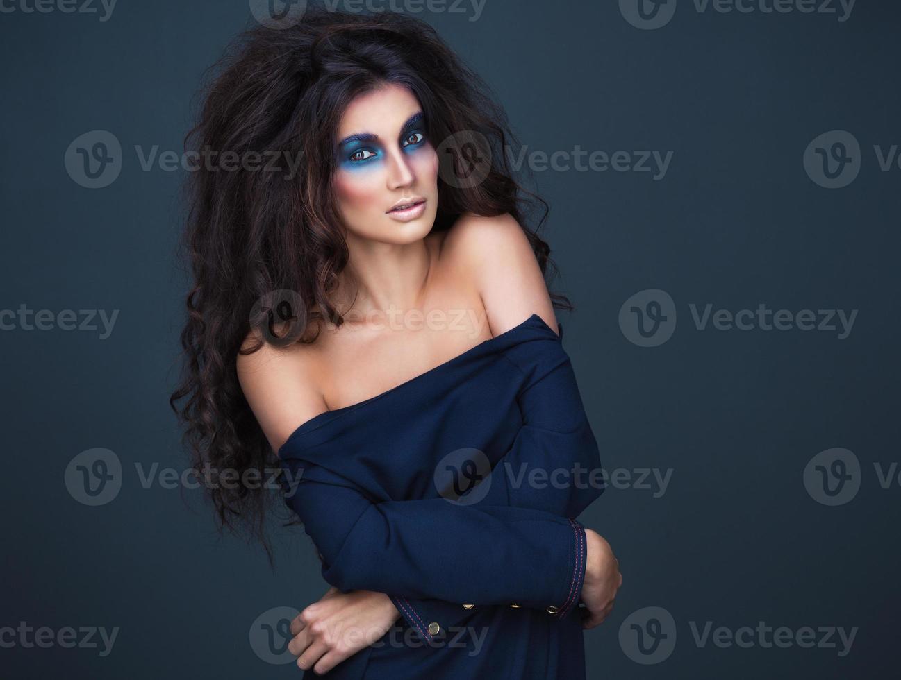 Portrait of a young girl with a fashion dark  makeup of eyes and and bulk hair photo