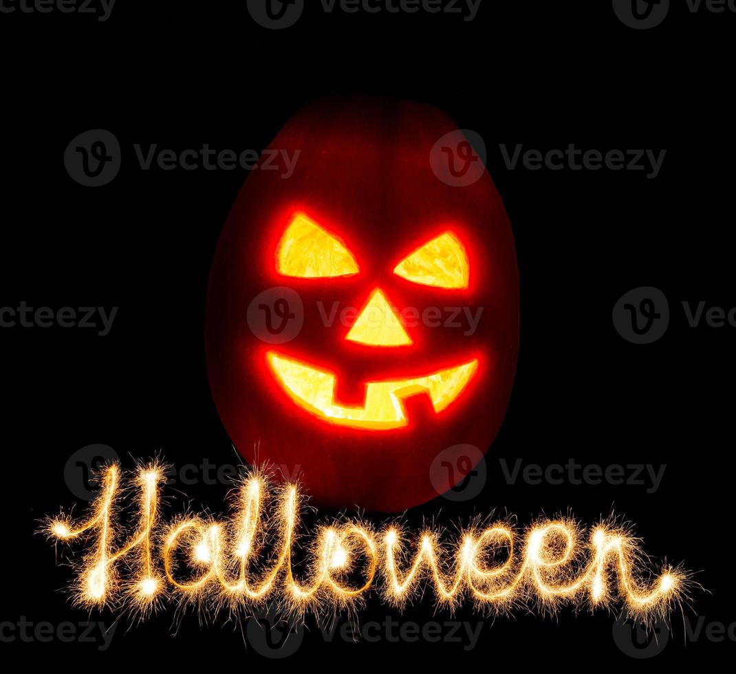 Víspera de Todos los Santos calabaza Jack-o-lantern vela iluminado y el inscripción Víspera de Todos los Santos bengalas foto