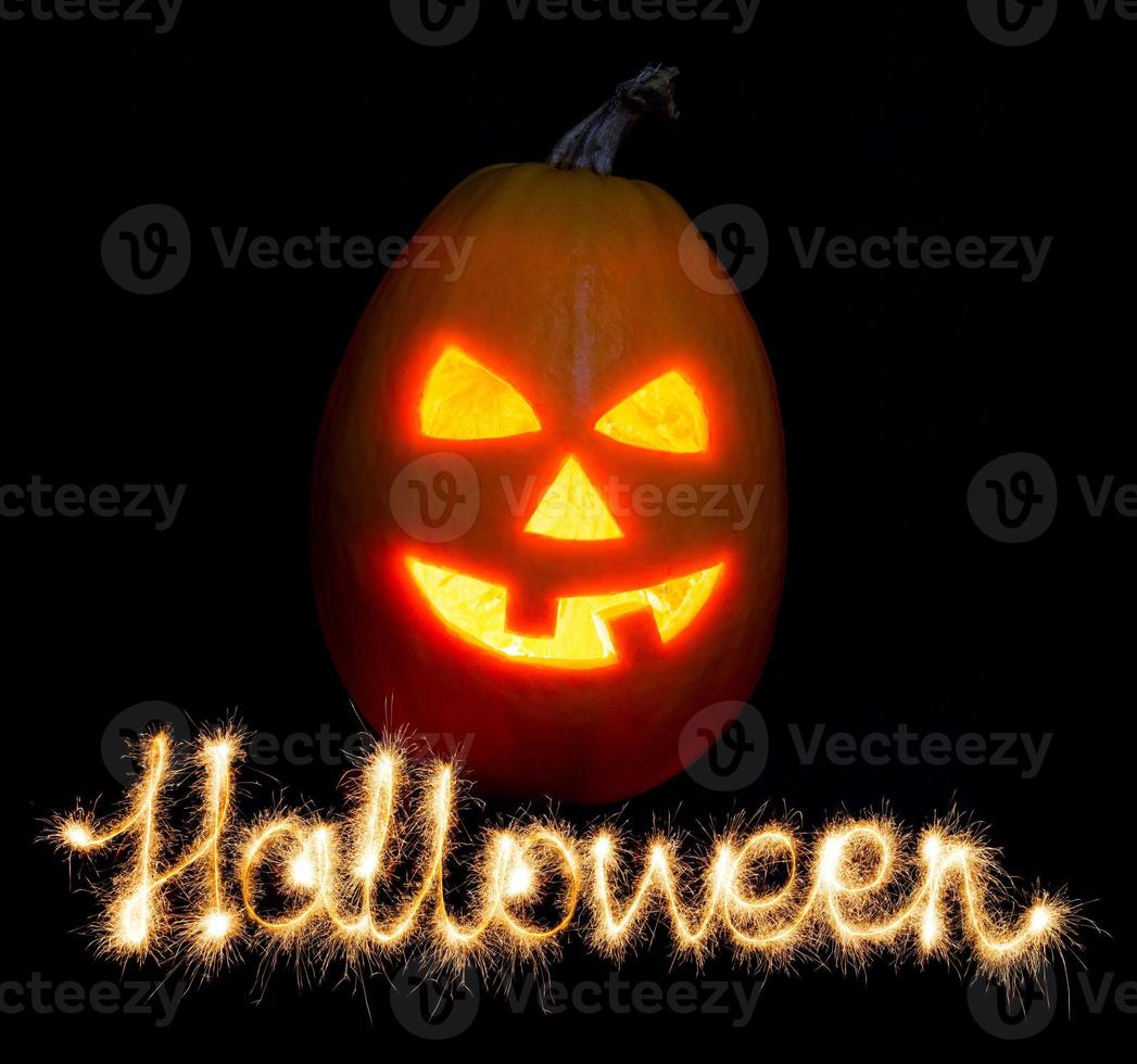 Víspera de Todos los Santos calabaza Jack-o-lantern vela iluminado y el inscripción Víspera de Todos los Santos bengalas foto