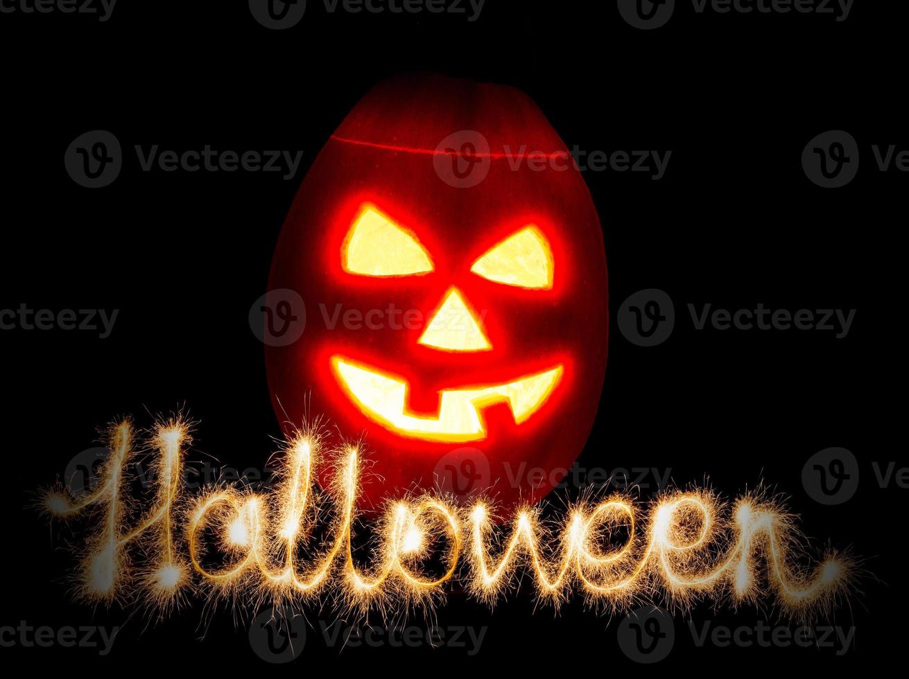 Halloween pumpkin jack-o-lantern candle lit and the inscription Halloween sparklers photo