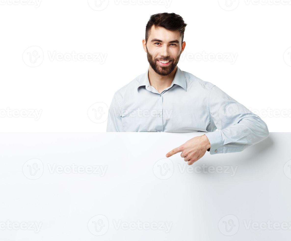 un joven barbado hombre demostración blanco letrero, aislado terminado blanco foto