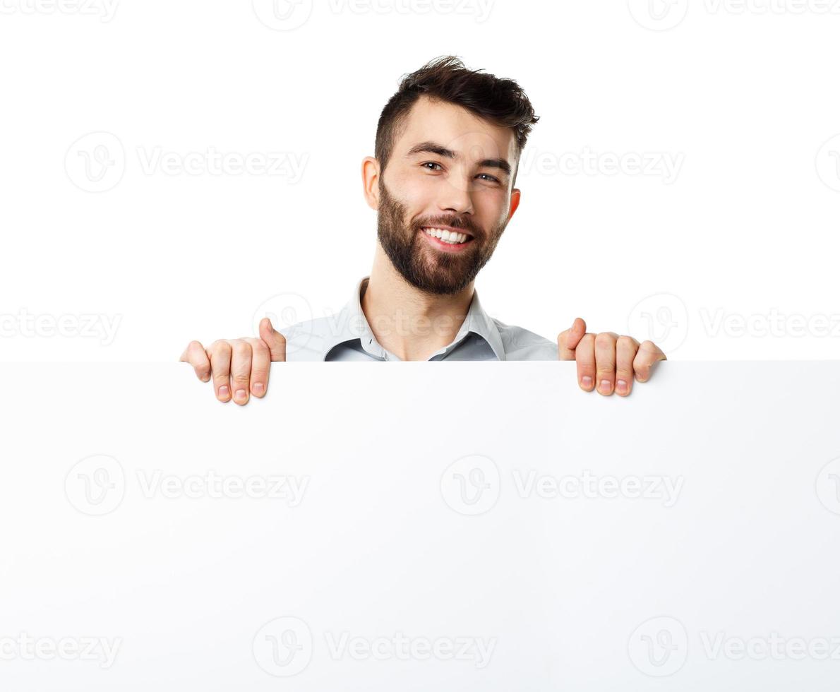 A young bearded man showing blank signboard, isolated over white photo