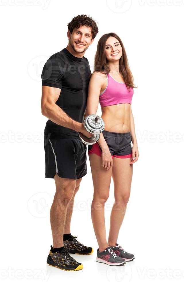 Athletic man and woman with dumbbells on the white photo