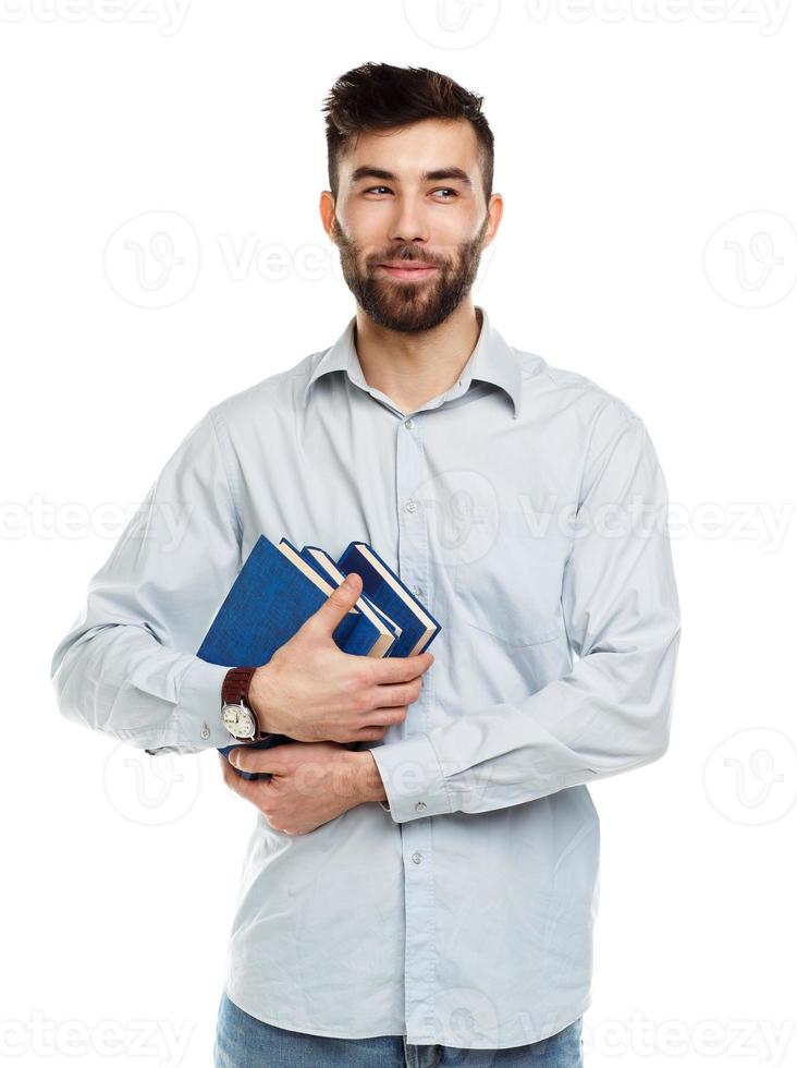 Young bearded smiling man with books in hand on white photo