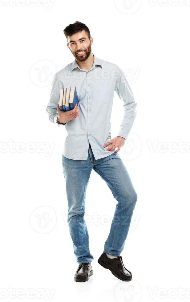 Young bearded smiling man with books in hand on white photo