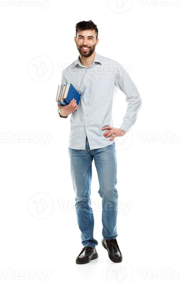 Young bearded smiling man with books in hand on white photo
