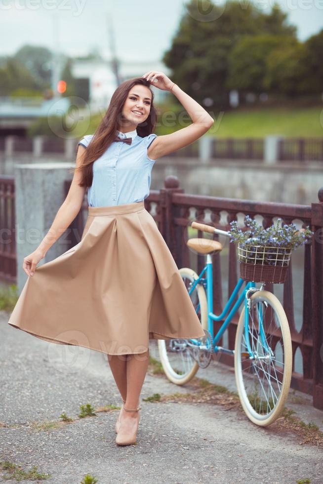 Young beautiful, elegantly dressed woman with bicycle photo