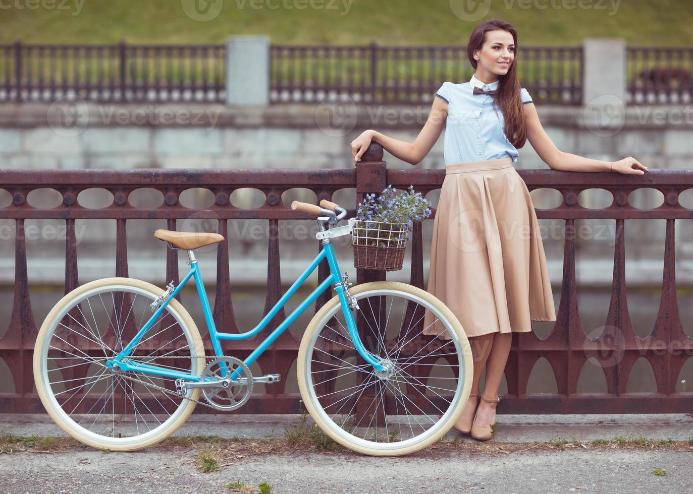 joven mujer hermosa, elegantemente vestida con bicicleta foto