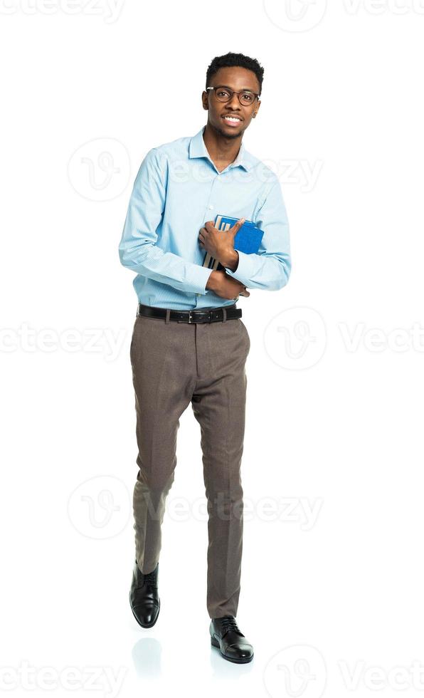 Happy african american college student standing with books in his hands on white photo