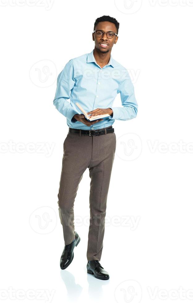 Happy african american college student standing with book on white photo