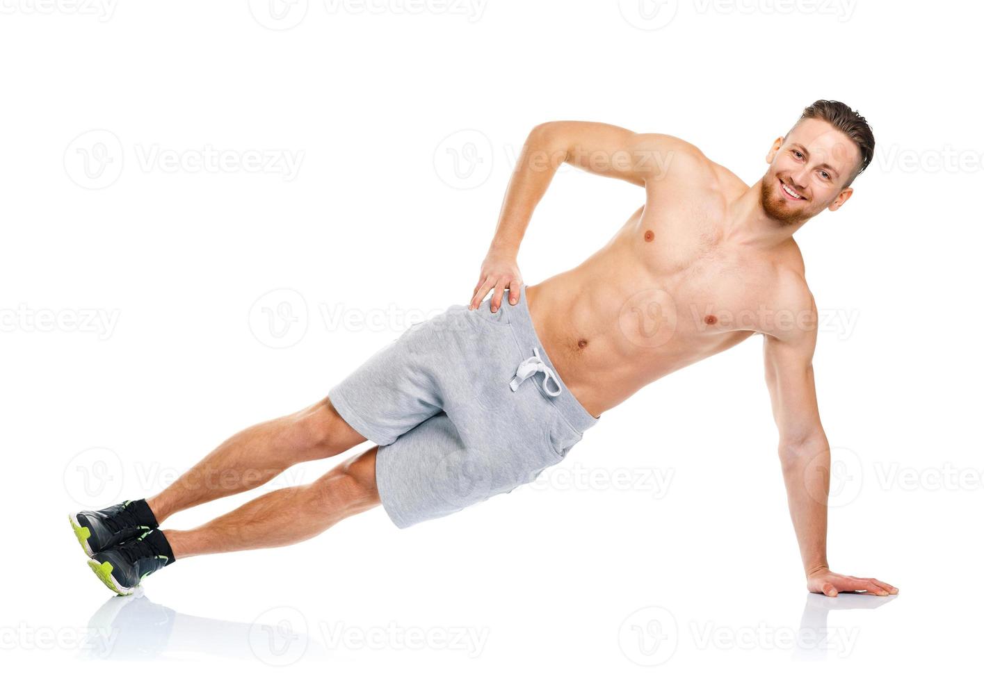 Athletic attractive man doing fitness exercises on the white photo