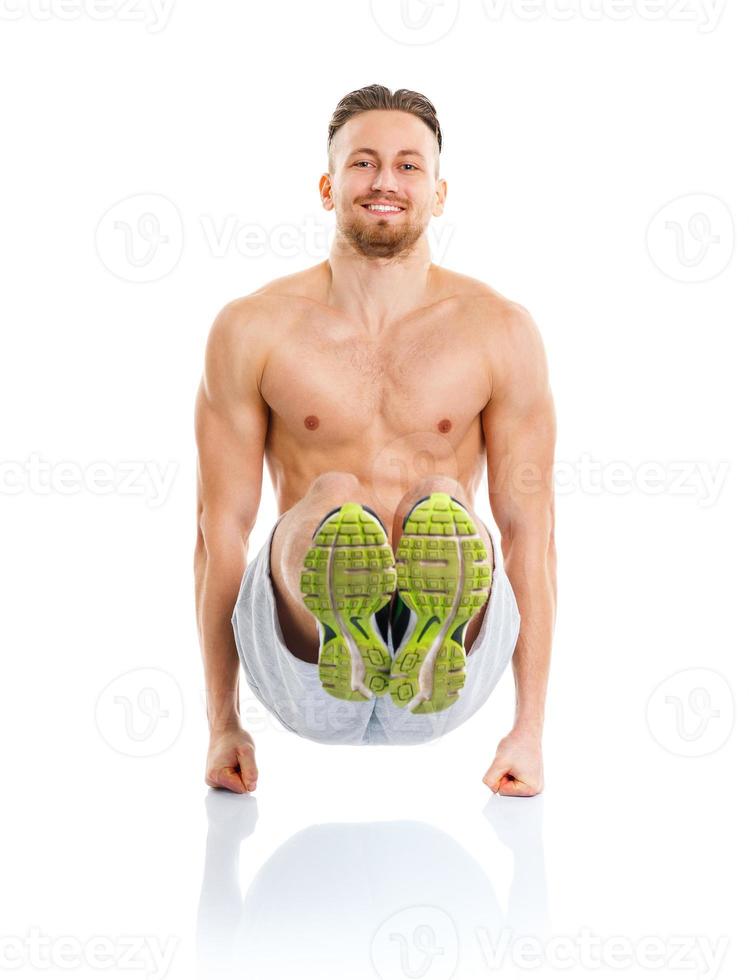 Athletic attractive man doing fitness exercises on the white photo