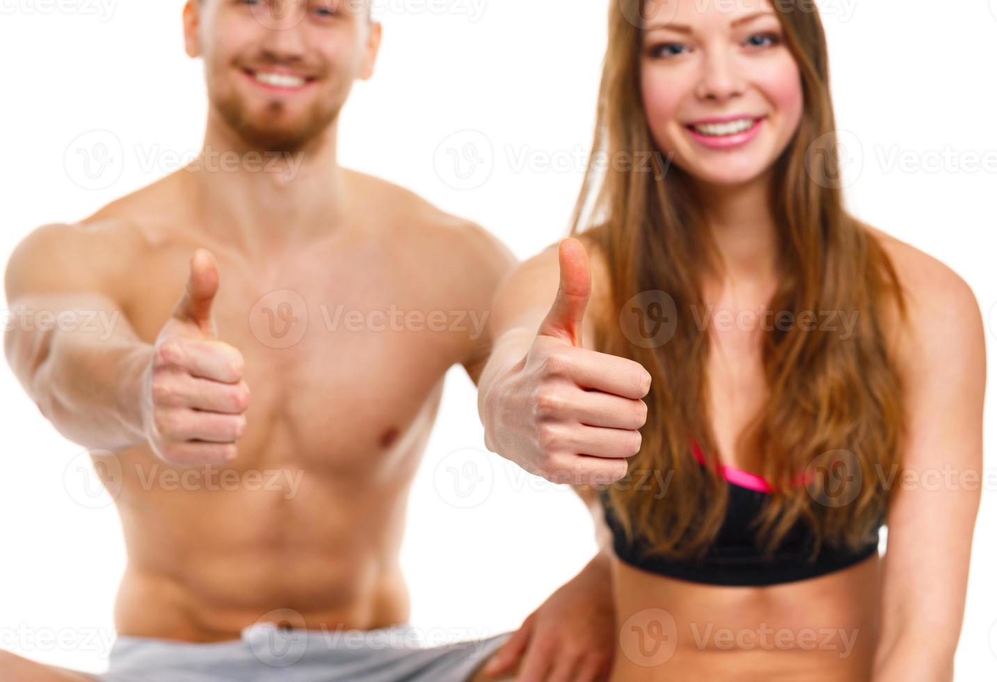 Athletic man and woman after fitness exercise with a finger up on the white photo