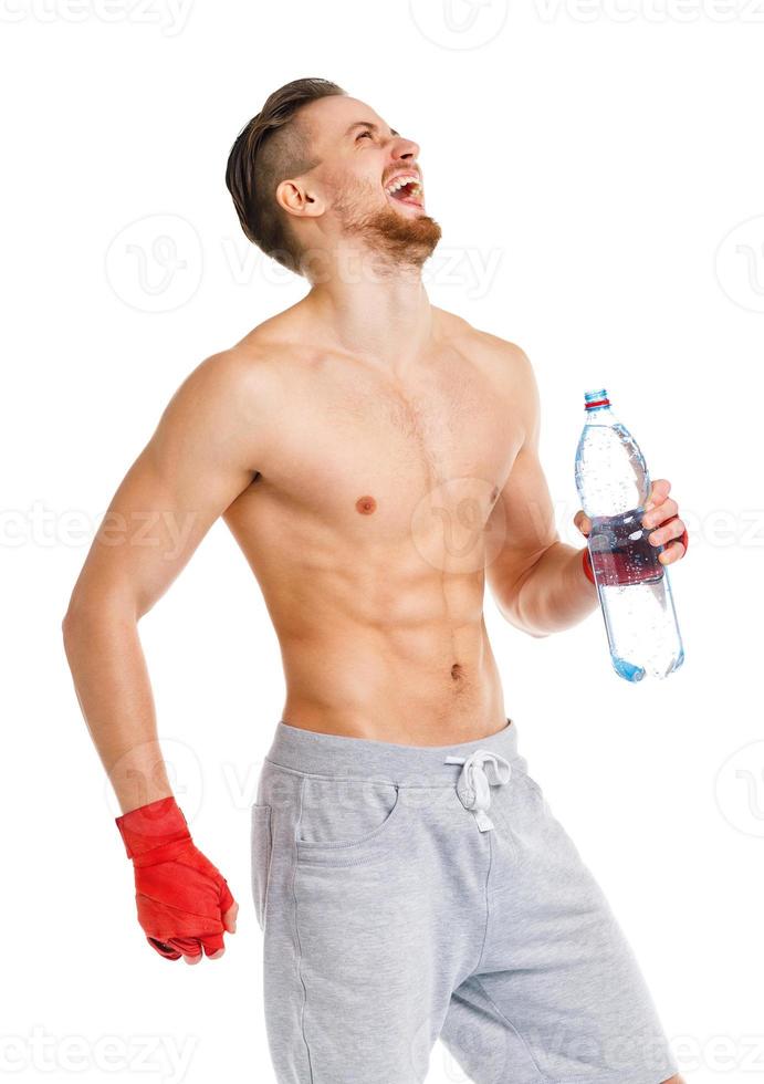 Smilling athletic attractive man wearing boxing bandages with bottle of water on the white photo