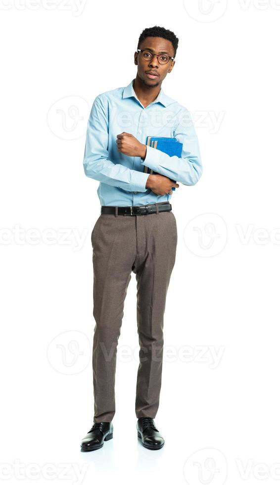 Happy african american college student standing with books in his hands on white photo