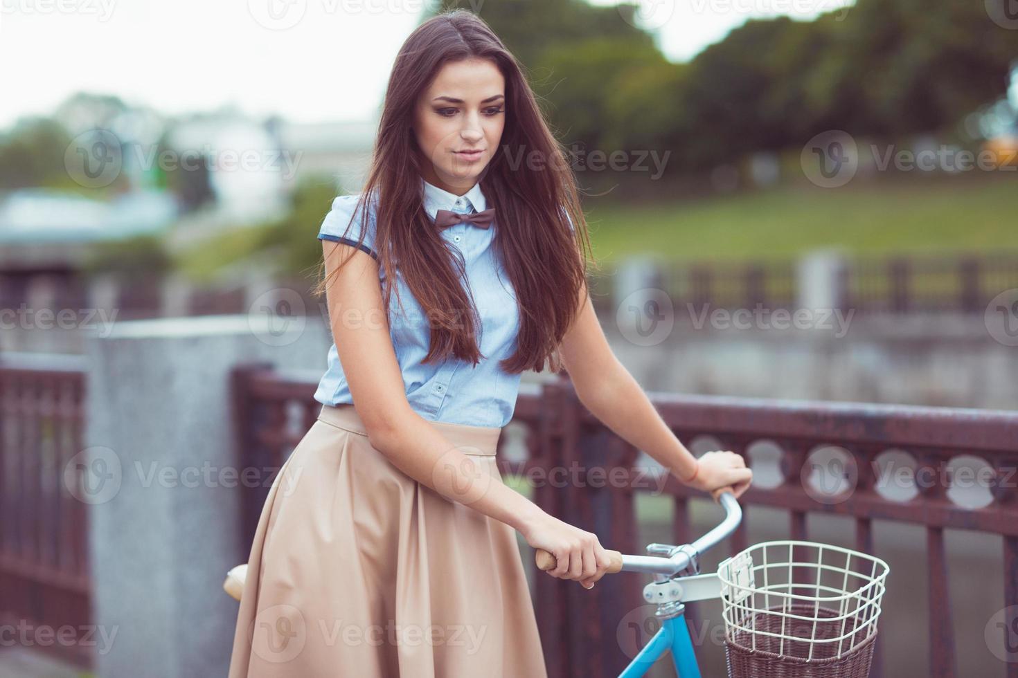 Young beautiful, elegantly dressed woman with bicycle photo