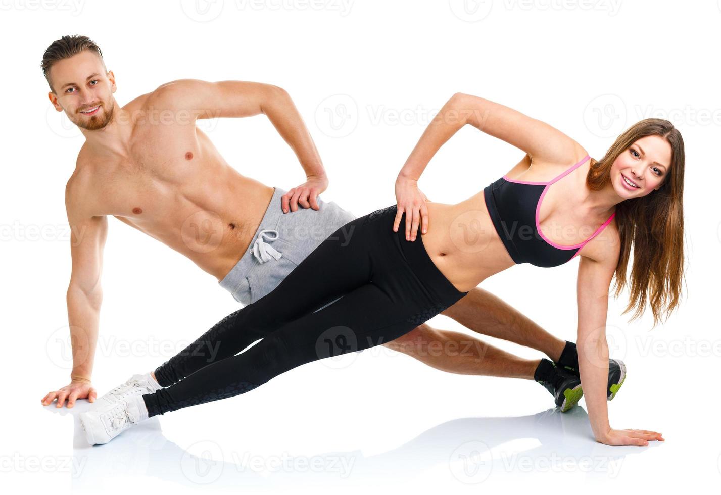 Sport attractive couple - man and woman doing fitness exercises on the white photo