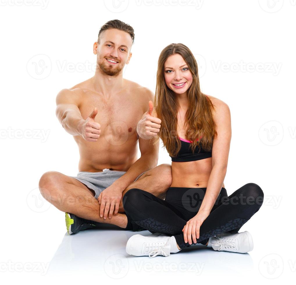 Sport man and woman after fitness exercise with a finger up on the white photo
