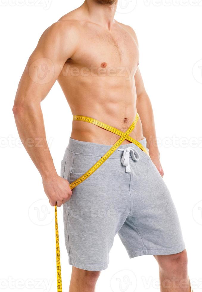 Athletic man with measuring tape on the white photo