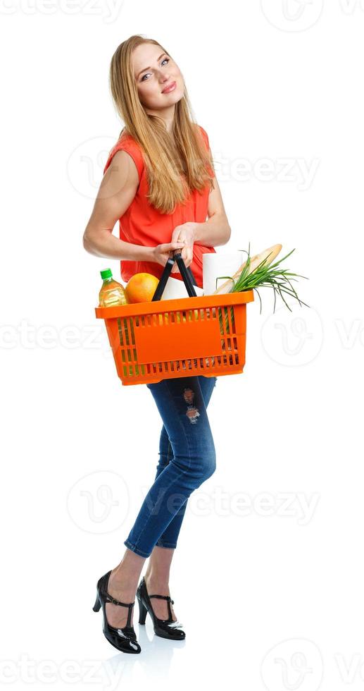 Happy woman holding a basket full of healthy food. Shopping photo