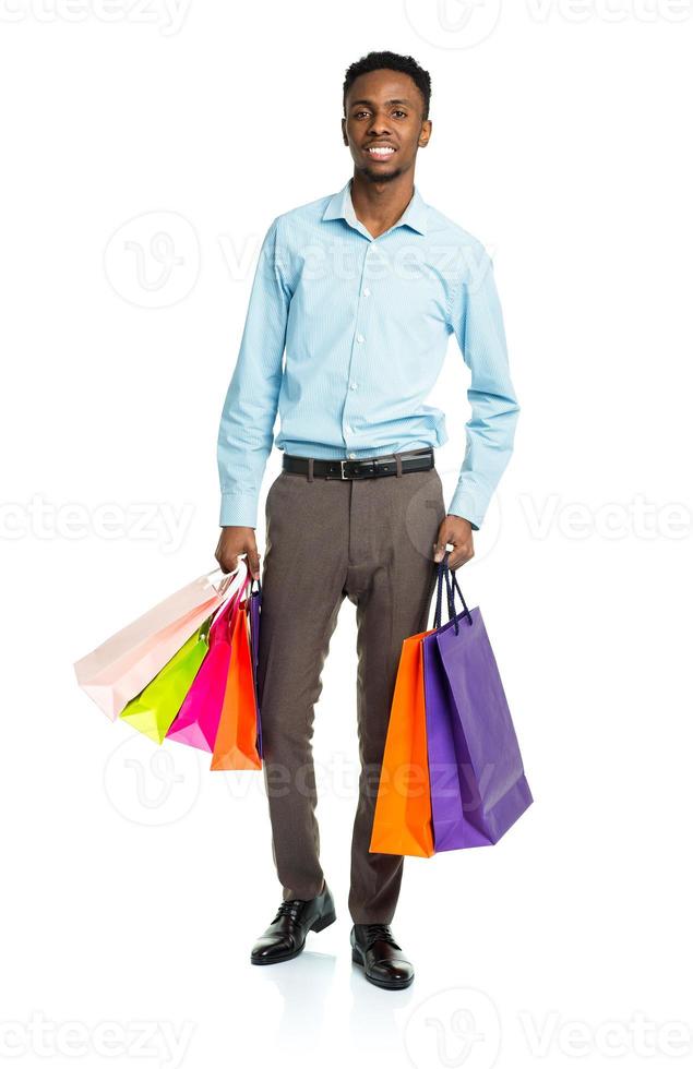 Happy african american man holding shopping bags on white background photo