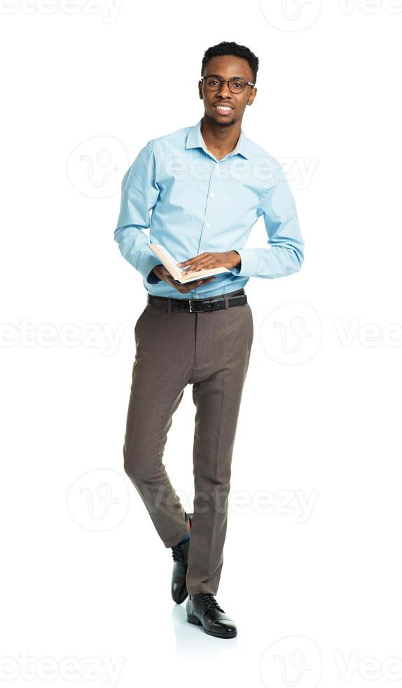 Happy african american college student with books in his hands standing on white photo