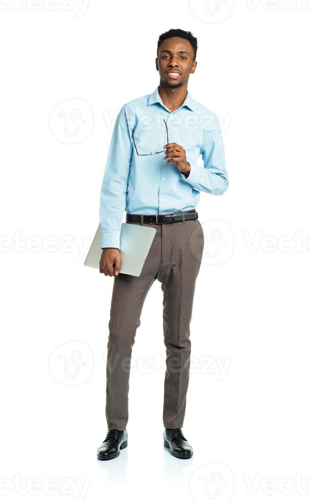 Happy african american college student with laptop standing on white photo