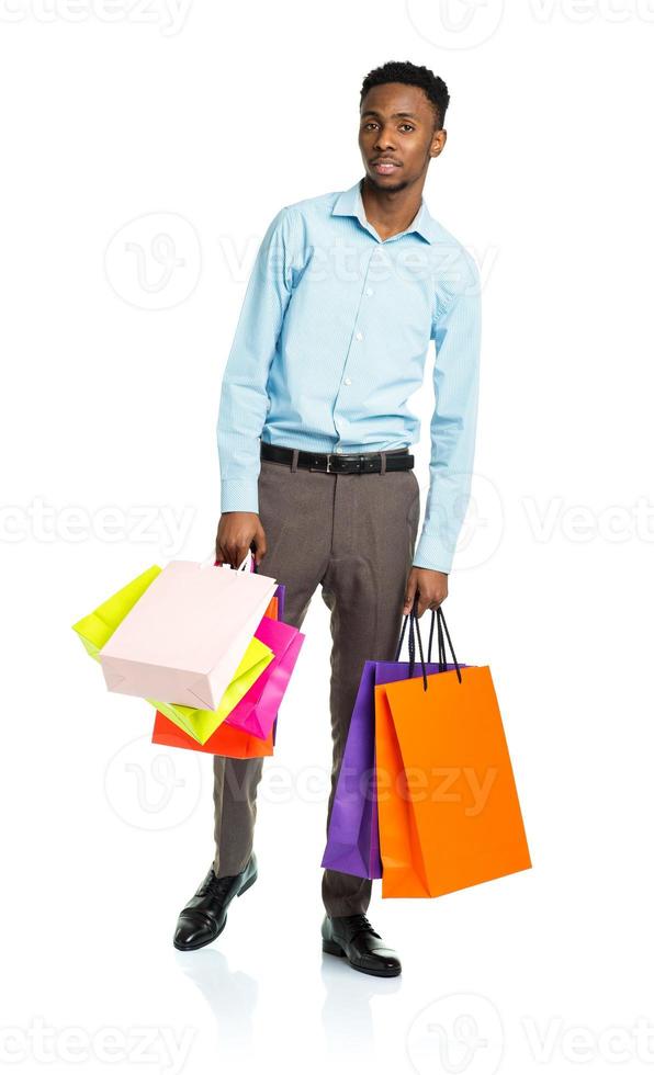 Happy african american man holding shopping bags on white background photo
