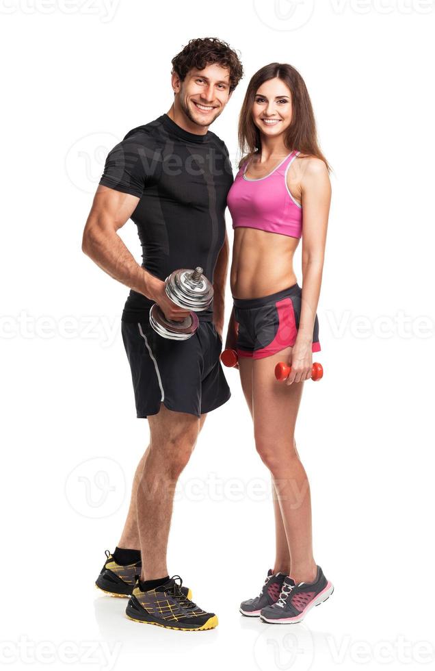 Sport couple - man and woman with dumbbells on the white photo