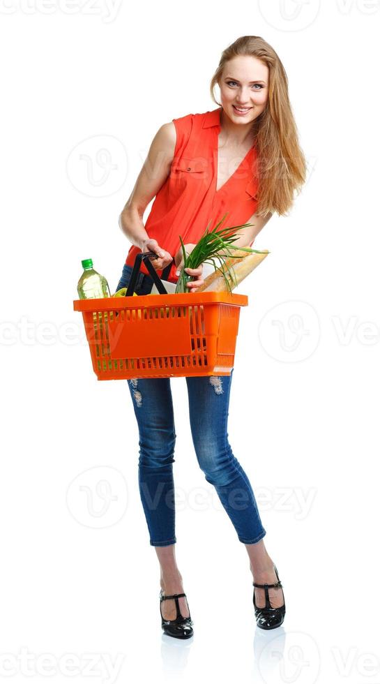 Happy woman holding a basket full of healthy food. Shopping photo