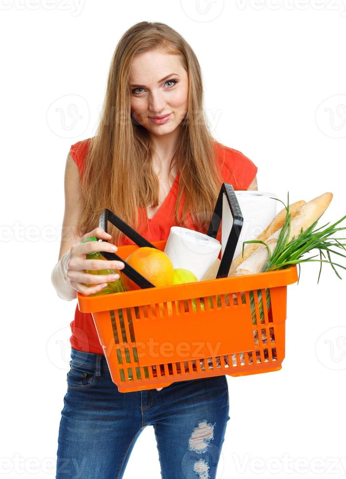 Happy woman holding a basket full of healthy food. Shopping photo