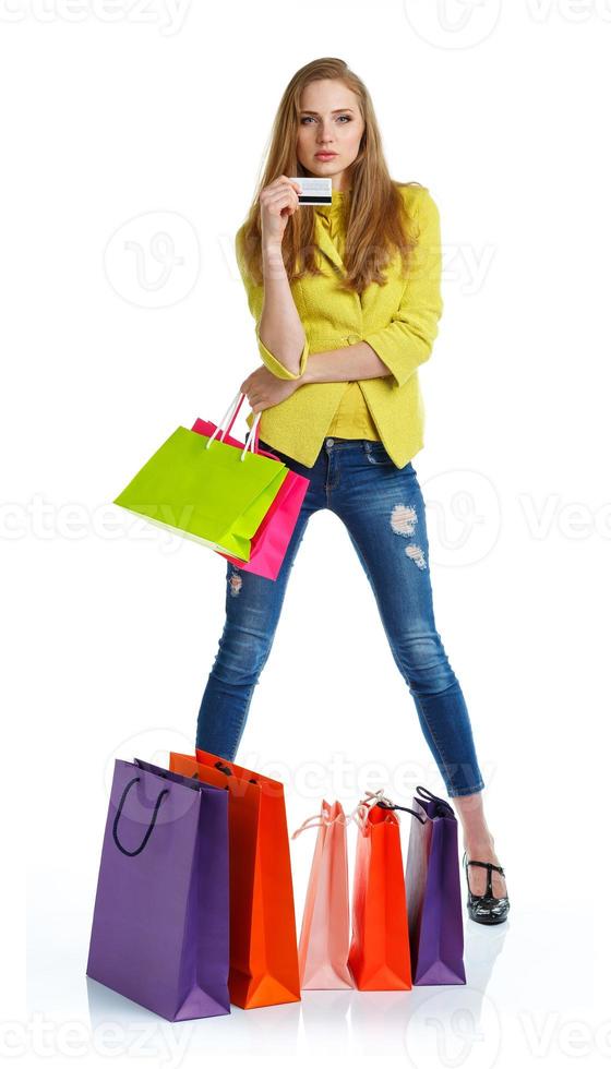 Happy lovely woman with shopping bags and credit card over white photo
