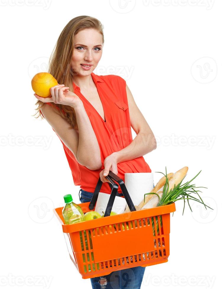 Happy woman holding a basket full of healthy food. Shopping photo