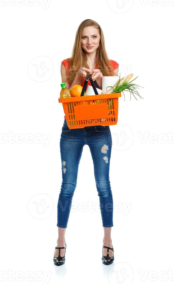 Happy woman holding a basket full of healthy food. Shopping photo