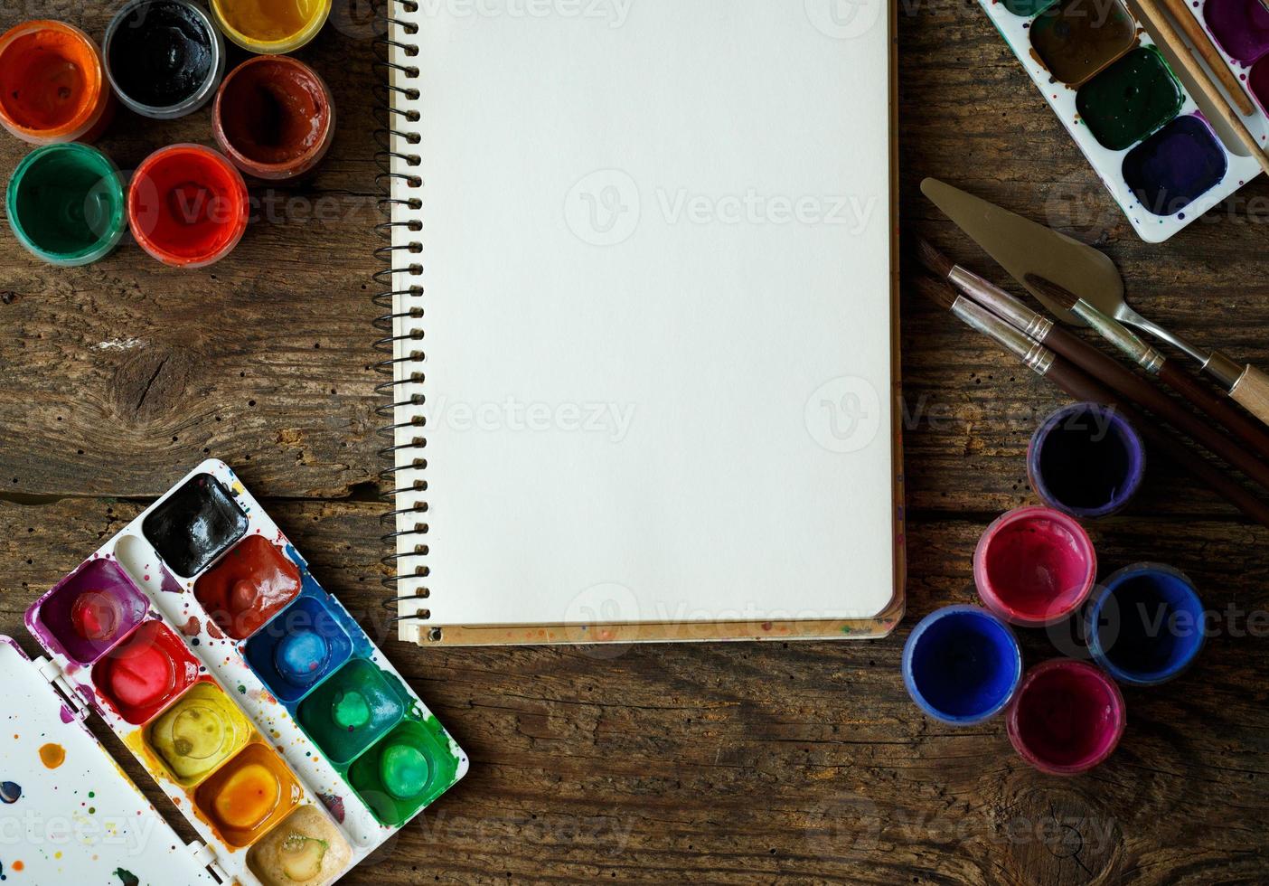 Painting set. Paper, brushes, paints, watercolor, acrylic paint on a wooden background top down view photo