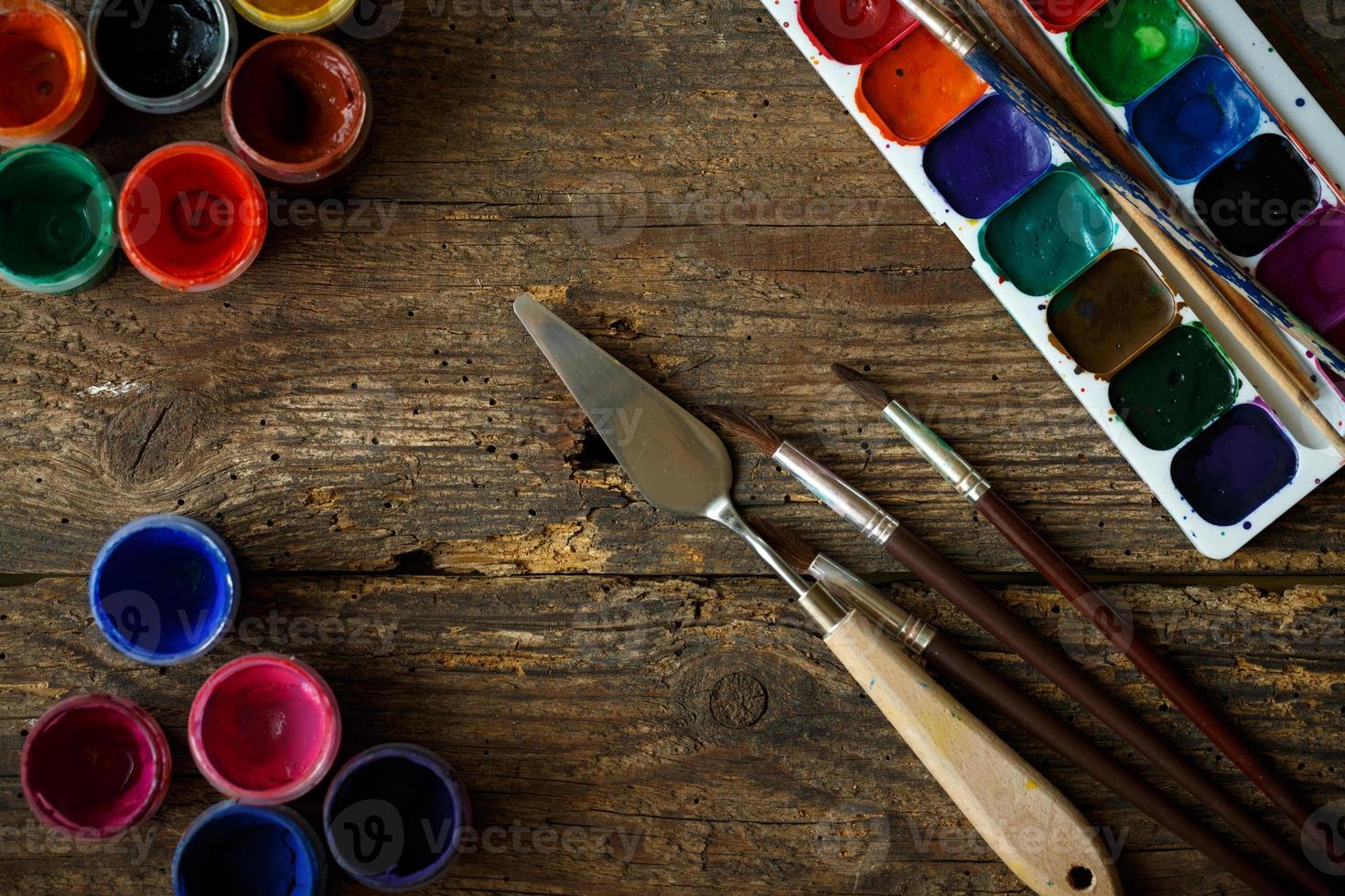 Painting set with brushes, paints, watercolor, acrylic paint on a white wooden background top down view photo