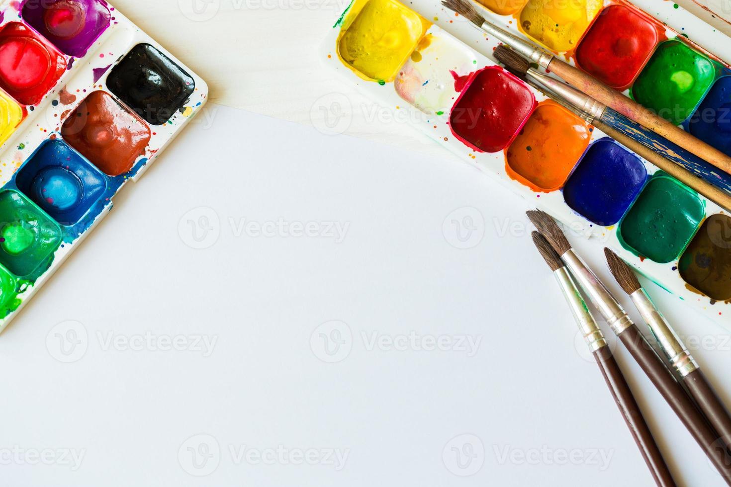 Painting set with brushes, paints, watercolor, acrylic paint on a white wooden background top down view photo