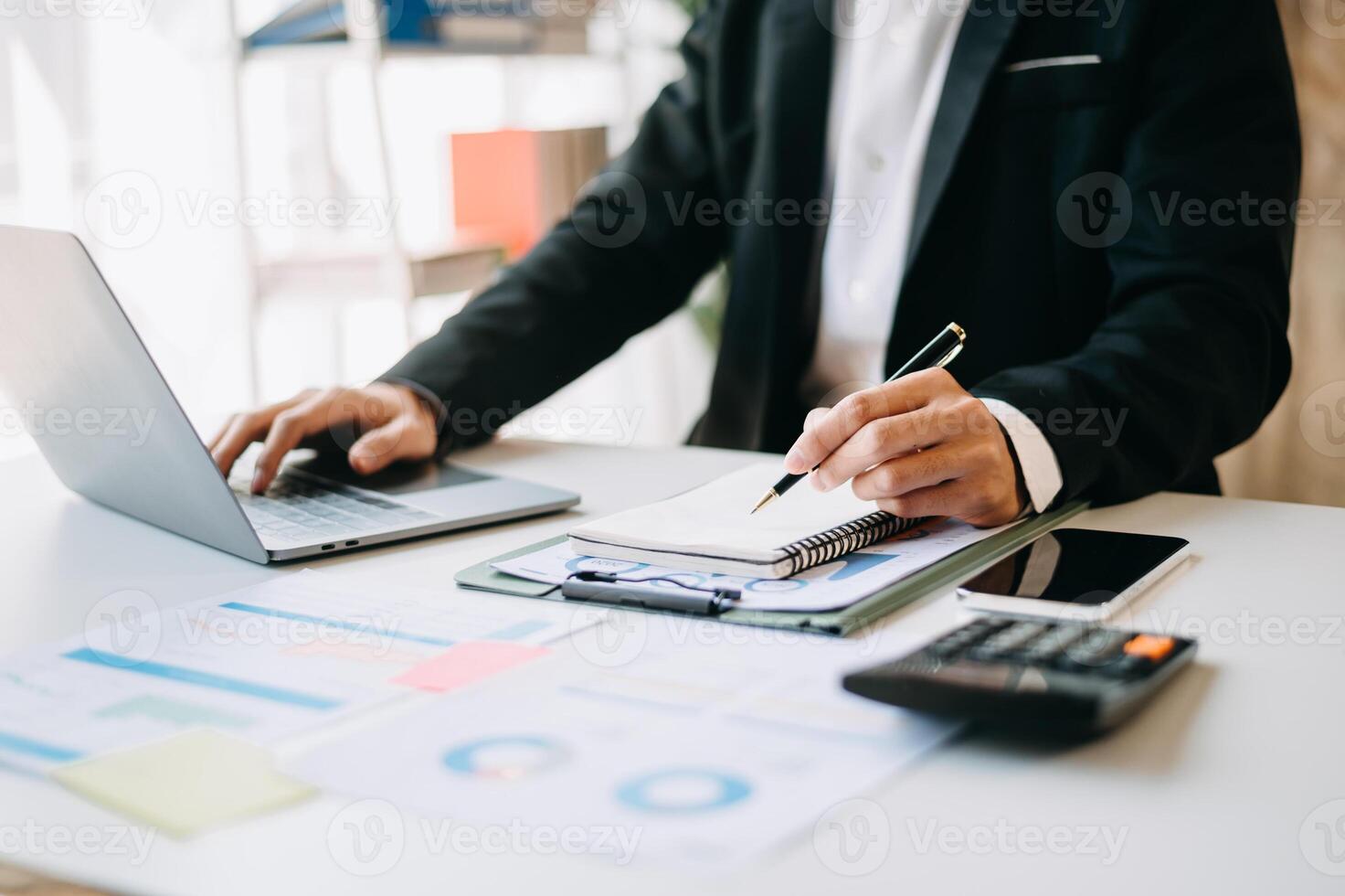 business documents on office table with smart phone and digital tablet and graph financial and woman working at office photo