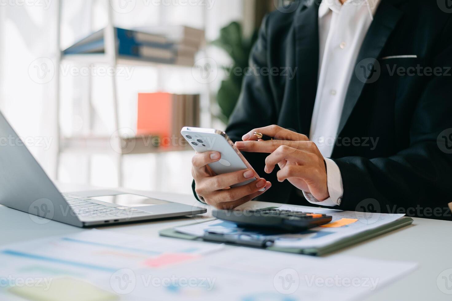 business documents on office table with smart phone and digital tablet and graph financial and woman working at office photo