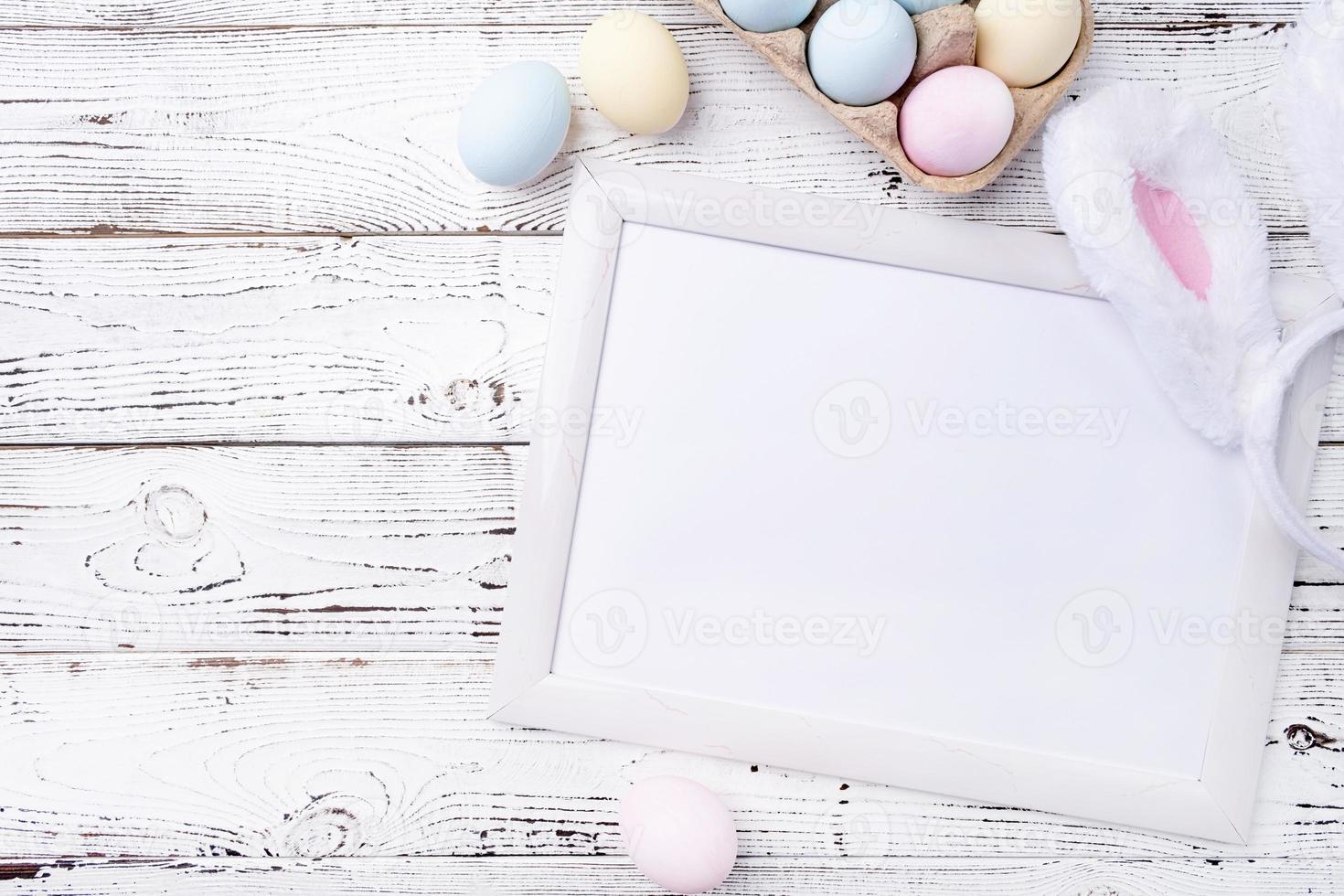 Pastel colored Easter eggs with blank white frame for mockup design photo