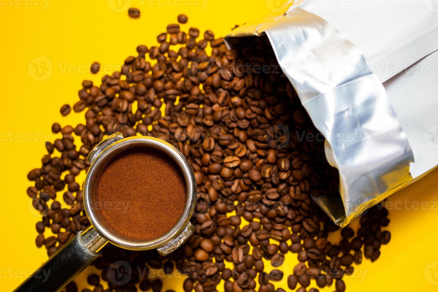 An open bag of fresh coffee beans. Holder filter with ground coffee for coffee machines. Selective focus. Close up. photo