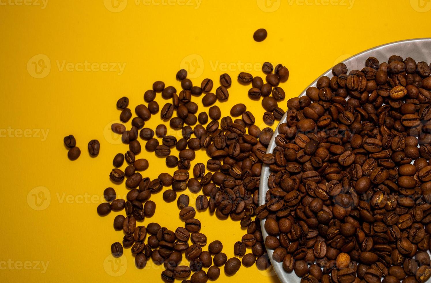 Coffee beans isolated on the yellow background. Joyful minimal coffee-theme with copy space photo