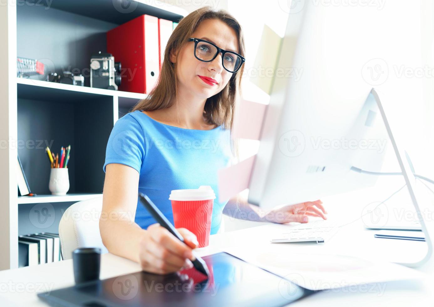Graphic designer drawing something on graphic tablet at the home office photo