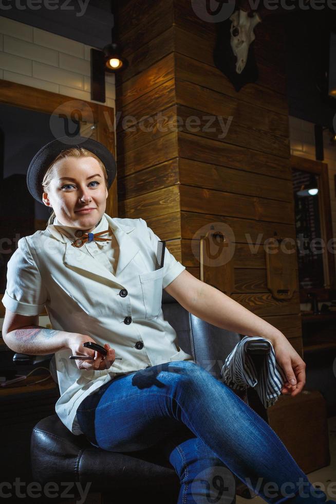Fashion woman barber hairstylist with straight razor in hand in the barbershop photo