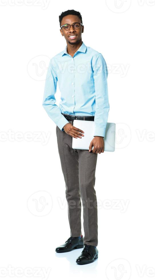 Happy african american college student standing with laptop on white photo