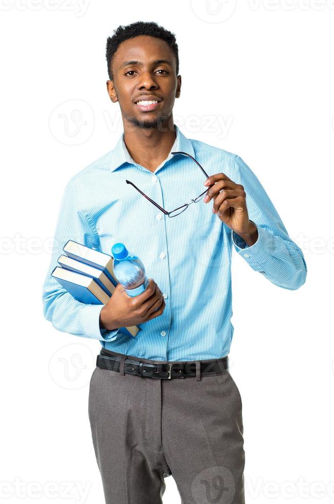 contento africano americano Universidad estudiante en pie con libros y botella de agua en su manos en blanco foto