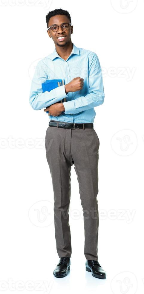 Happy african american college student standing with books in his hands on white photo