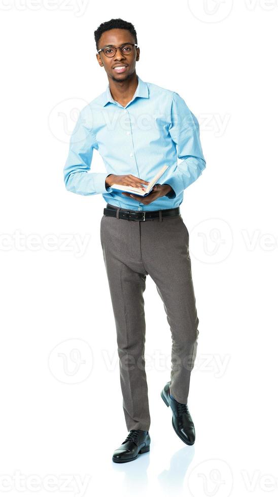 Happy african american college student standing with book on white photo