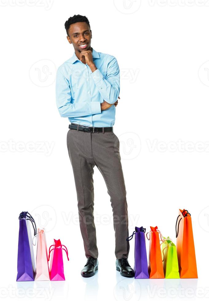 contento africano americano hombre con compras pantalones en blanco antecedentes foto